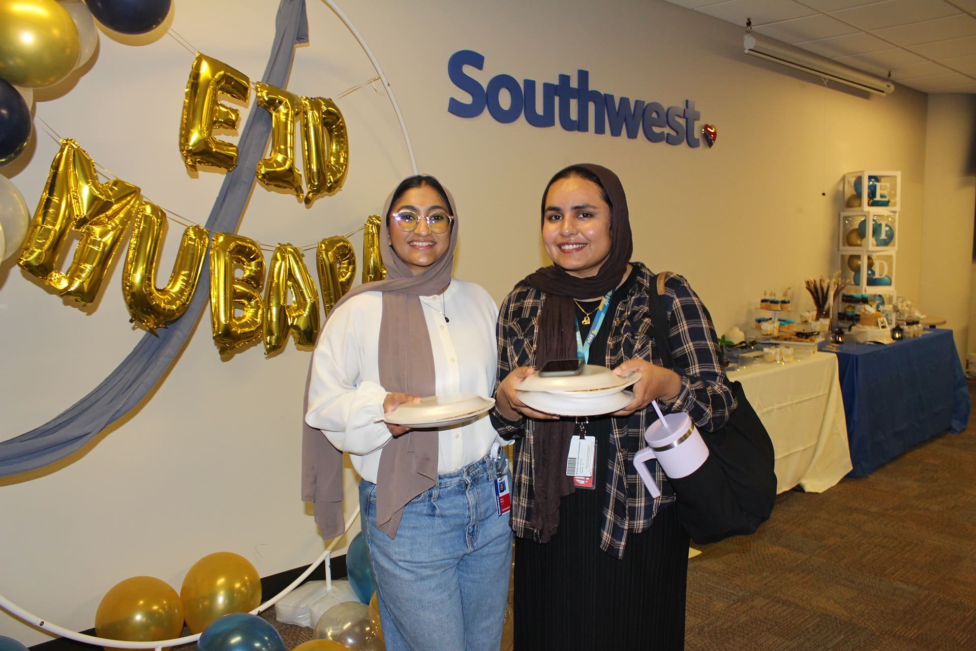 Two guests smiling together at a workplace celebration