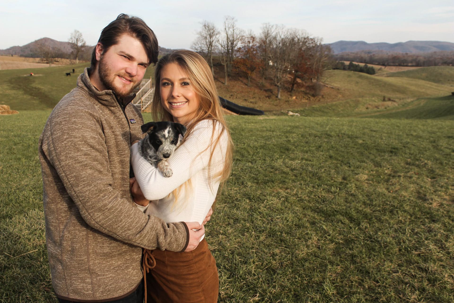 Couple holding their puppy during an outdoor portrait session