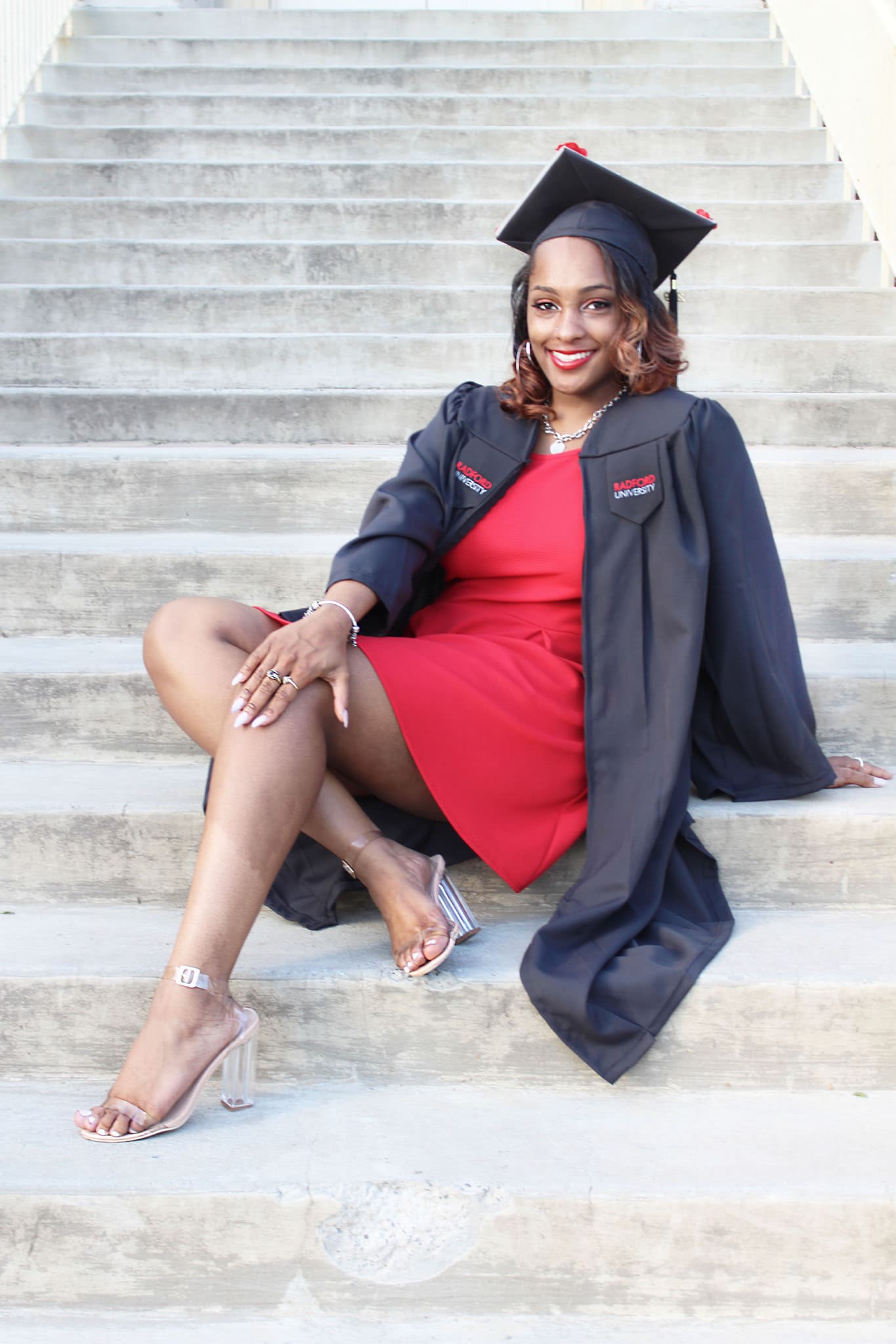 Graduate seated on stone steps in warm evening light