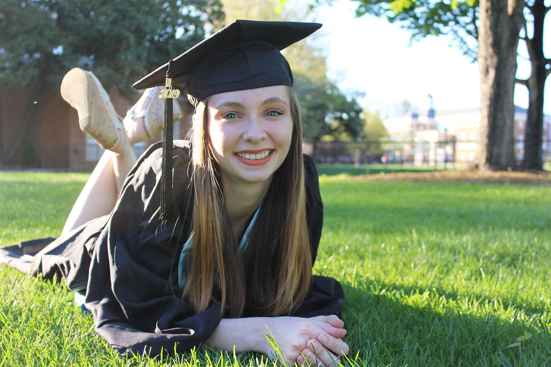 Graduate relaxing in the grass during a portrait session
