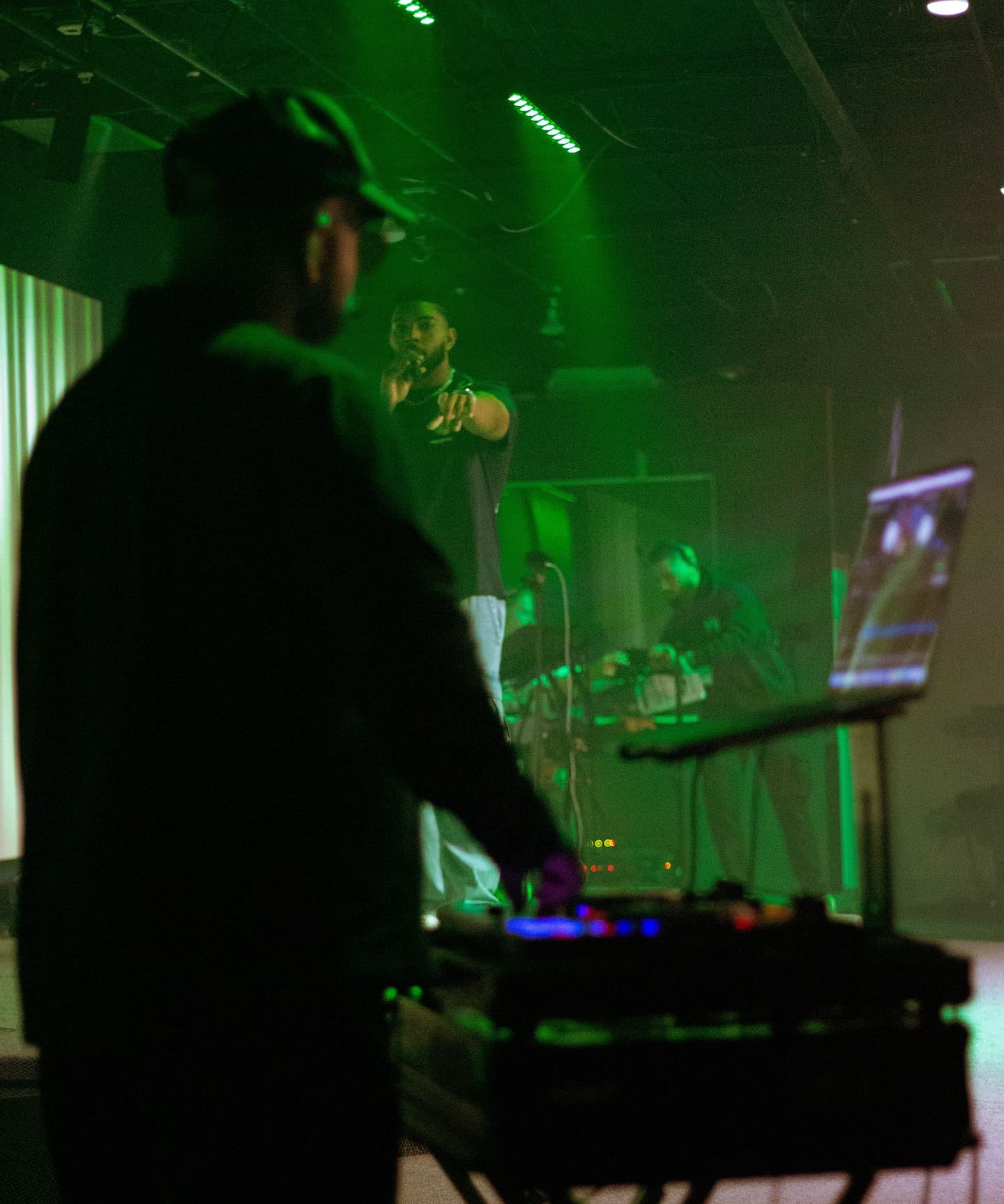 Musician performing under deep green stage light