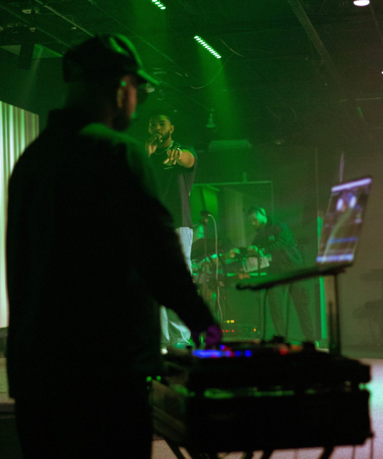 Performer lit in deep green during a live event